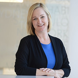 A woman in a suit smiling.